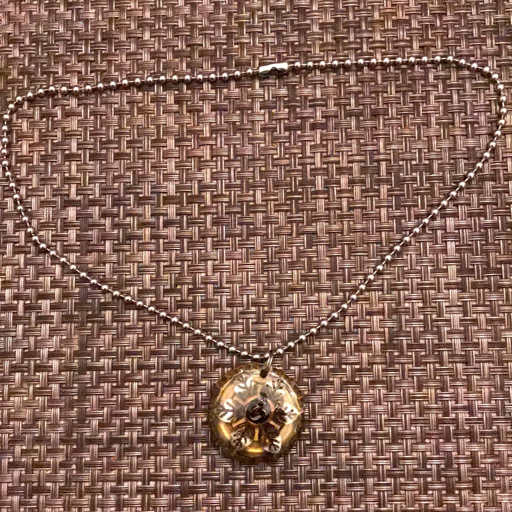 Bottle cap flower necklace on a tab bottle cap
